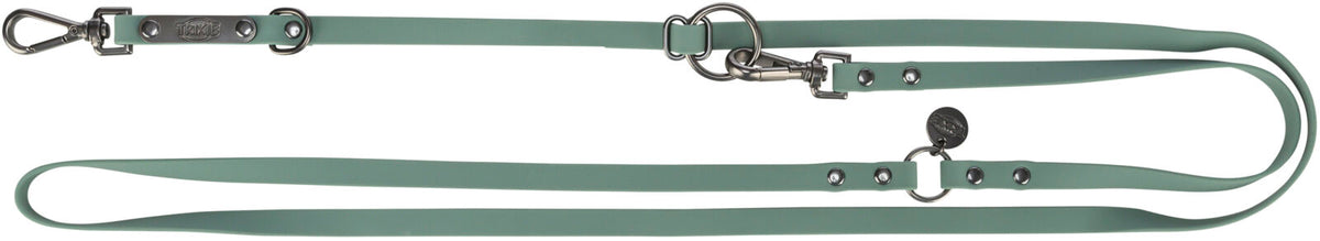 Grüne Hundeleine mit Metallbeschlägen, Ringen und Karabinern, aufgedruckter Schriftzug "TRIXIE".
