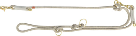 Beigefarbene Hundeleine mit Knoten und goldfarbenen Karabinern aus Metall.