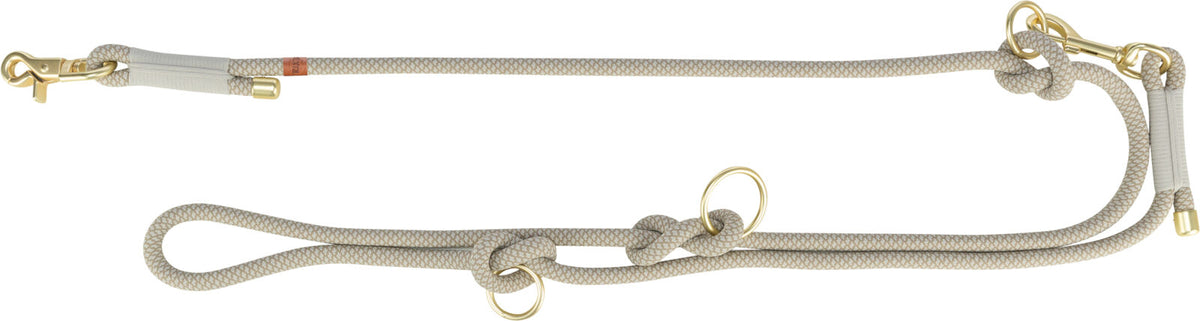 Beigefarbene Hundeleine mit Knoten und goldfarbenen Karabinern aus Metall.