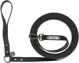 Schwarze, aufgerollte Hundeleine mit Karabiner und Griff, Metallschild mit "TRIXIE"-Logo sichtbar.