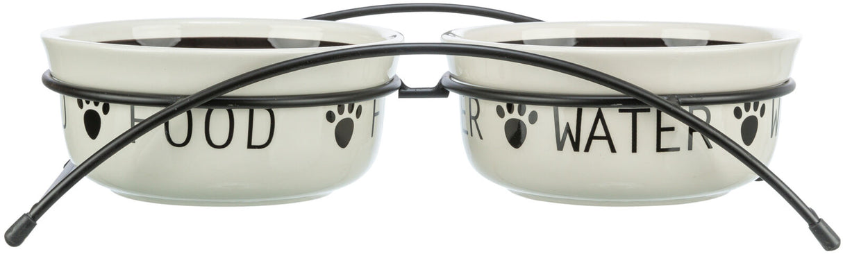 Zwei cremefarbene Schalen mit schwarzem Schriftzug "FOOD" und "WATER", gehalten in einem schwarzen Metallständer.