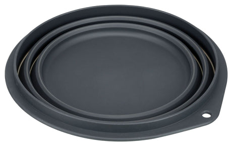 Rundes, dunkelgraues Objekt mit mehreren Kanten, flache Form und einem kleinen Loch am Rand sichtbar.