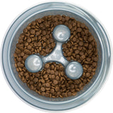 Runde, durchsichtige Schale mit braunen Trockenfutterstücken und einem dreiförmigen grauen Einsatz in der Mitte.
