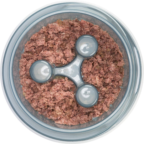 In einer runden, transparenten Schale befindet sich gleichmäßig verteilt eine rosafarbene, grobe Masse.