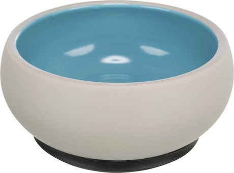 Beigefarbene Schale mit blauer Innenseite und einem dunklen Sockel, schlichtes, modernes Design.