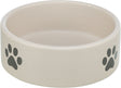 Beige Futternapf mit schwarzen Pfotenabdrücken an der Seite, rund und schlicht gestaltet.