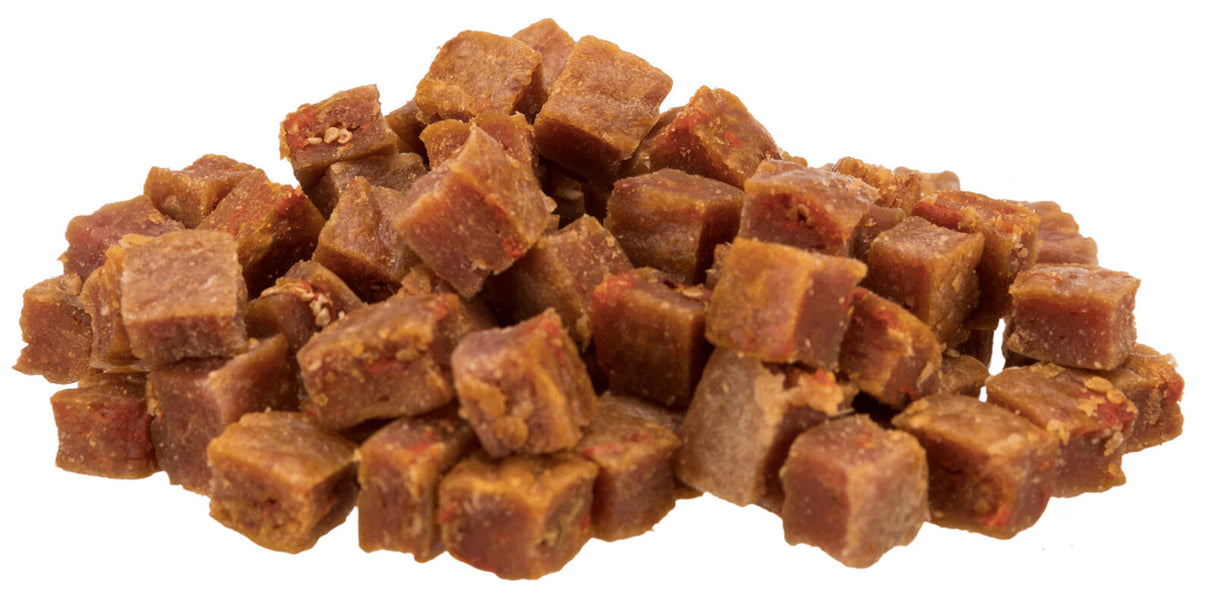 Würfelförmige, braune Snack-Stücke in einem Stapel, mit deutlich sichtbarer texturierter Oberfläche.