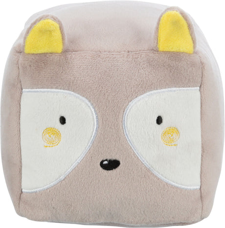 Graues, würfelförmiges Plüschtier mit stilisiertem Tiergesicht, weißen Augen und gelben Ohren, vereinzelt schwarze Details.