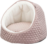 Ein weiches, rundes Hundebett in rosa mit wabenartiger Struktur und weißem, plüschigem Innenfutter.