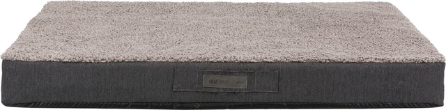Rechteckiges graues Hundebett mit weicher Oberfläche, Label "vitalEdition Trixie" sichtbar auf der Seite.