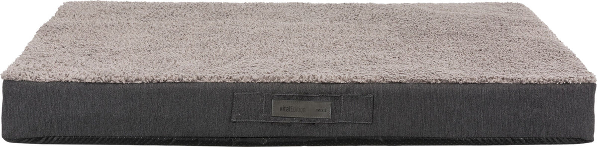Rechteckiges graues Hundebett mit weicher Oberfläche, Label "vitalEdition Trixie" sichtbar auf der Seite.