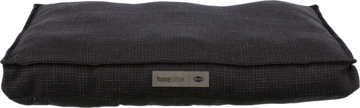 Rechteckiges, dunkles Kissen mit feinem Muster und einem Etikett mit der Aufschrift "homeEdition Trixie".