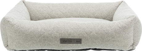 Rechteckiges, hellgraues Hundebett mit erhöhtem Rand und sichtbarem Etikett mit der Aufschrift "vitalEdition TRIXIE".