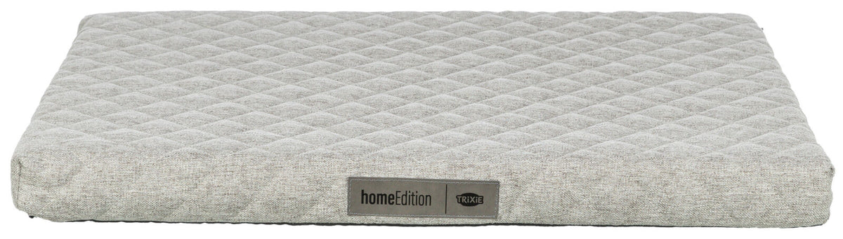 Graues, rechteckiges Polster mit rautenförmigem Muster, Label „homeEdition TRIXIE“ vorne sichtbar.