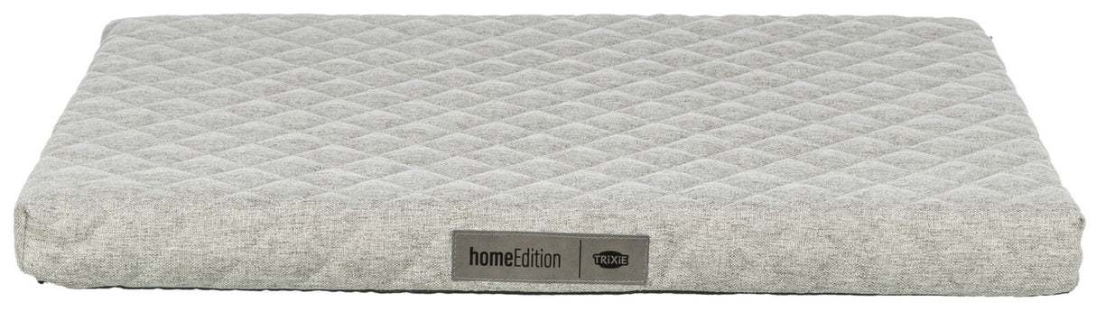 Graues, rechteckiges Polster mit rautenförmigem Muster, Label „homeEdition TRIXIE“ vorne sichtbar.
