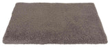 Rechteckige, flauschige, graue Matte mit texturierter Oberfläche, die auf einer weißen Fläche liegt.