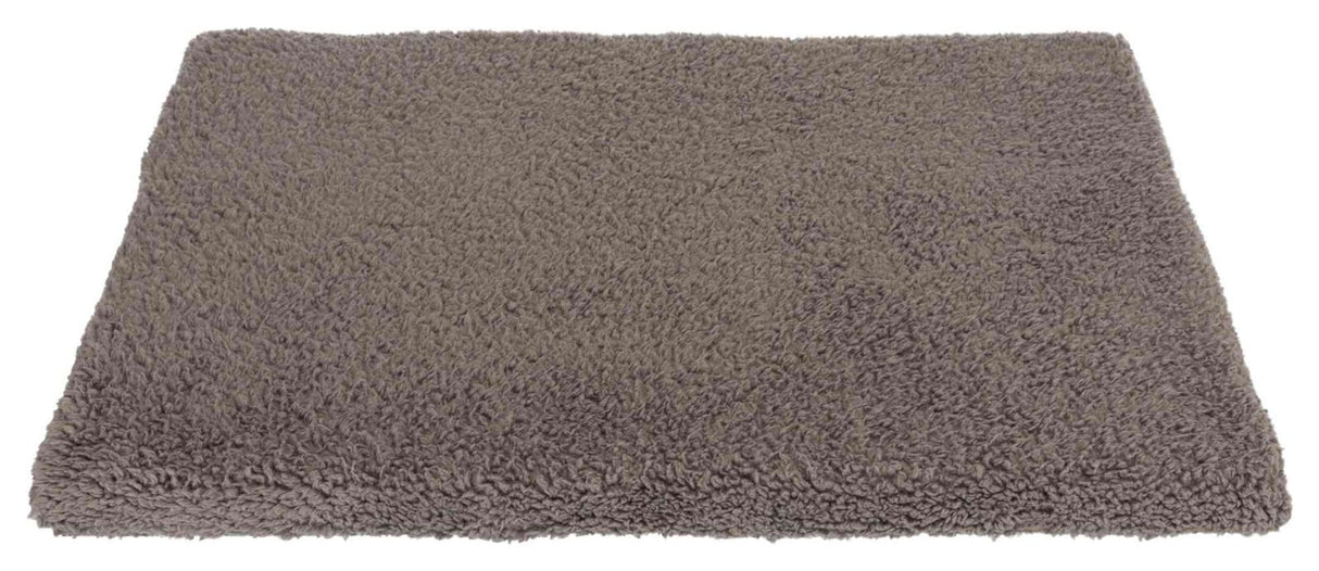 Rechteckige, flauschige, graue Matte mit texturierter Oberfläche, die auf einer weißen Fläche liegt.