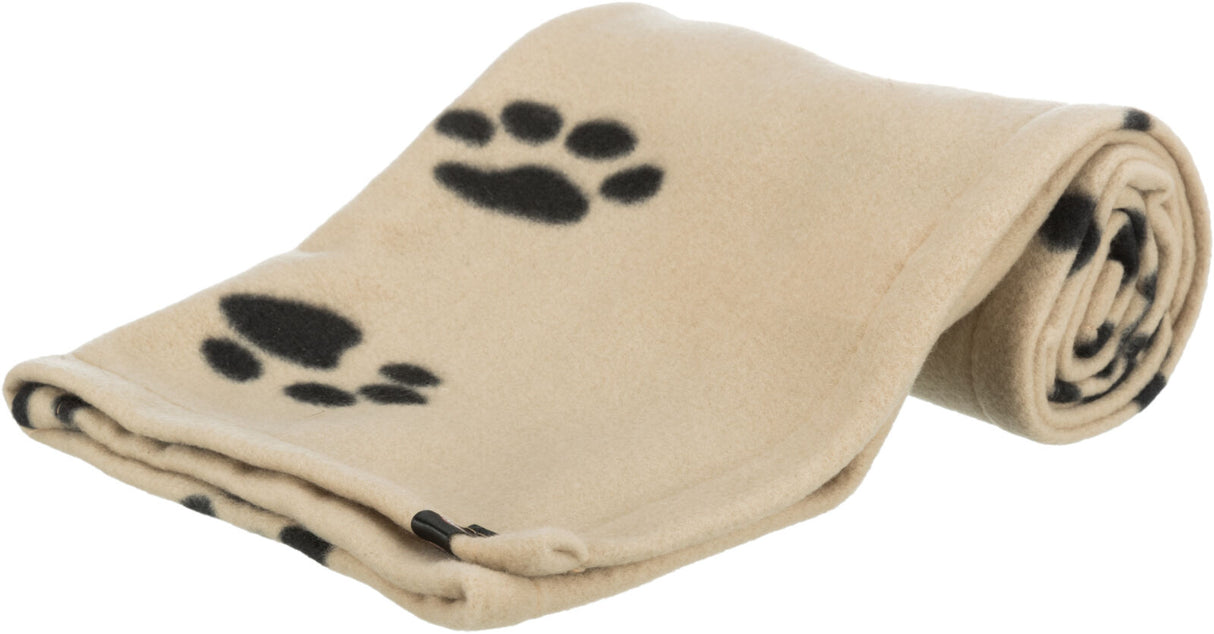 Beige Decke mit schwarzen Pfotenabdrücken, eine Hälfte gefaltet und die andere Hälfte aufgerollt.
