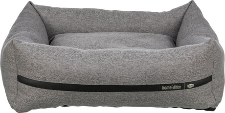 Graues, rechteckiges Hundebett mit erhöhtem Rand, Textur sichtbar, schwarzer Streifen, Aufschrift "homeEdition Trixie".