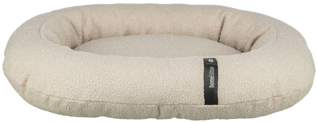 Rundes, hellbeiges Kissen mit strukturiertem Stoff und Stofflabel, erhöhtem Rand und flacher Liegefläche.