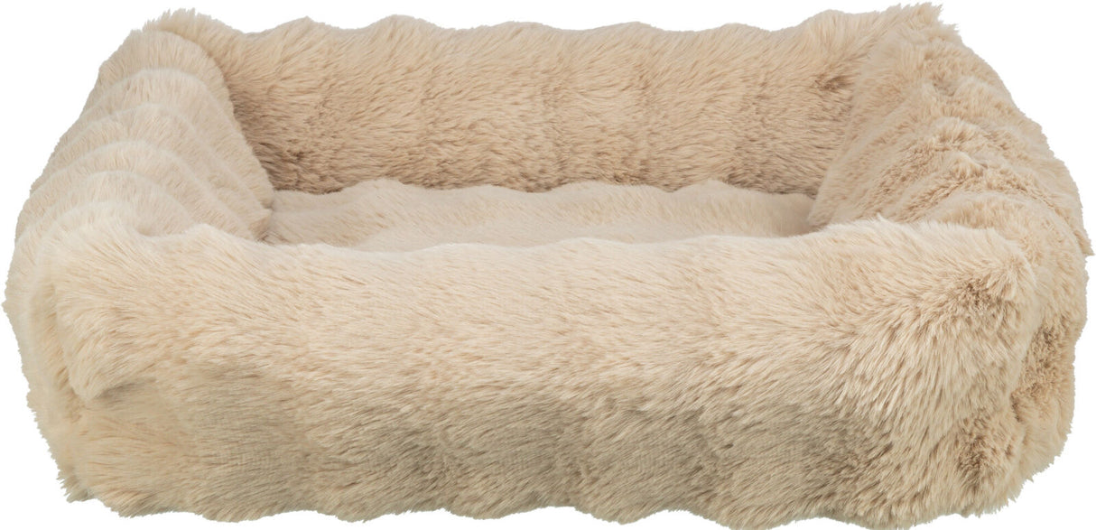 Weiches, cremefarbenes, rechteckiges Bett mit flauschiger Oberfläche und erhöhten Rändern.