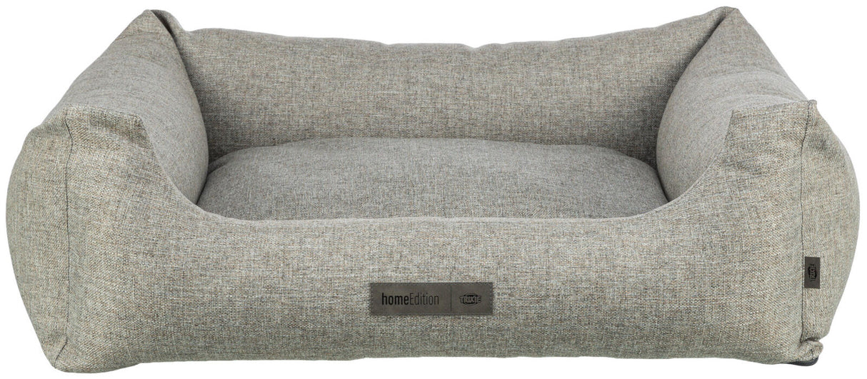 Graues, rechteckiges Hundebett mit erhöhten Seiten und sichtbarem Etikett mit der Aufschrift "homeEdition Trixie".