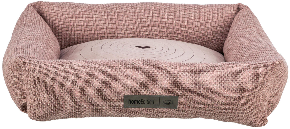 Rechteckiges, rosafarbenes Hundebett mit gepolstertem Herz-Design-Kissen, Stoffstruktur und Label "homeEdition".