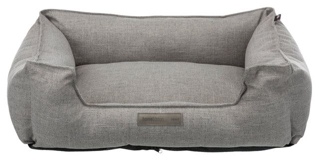 Graues Haustierbett in rechteckiger Sofaform mit erhöhtem Rand und einem Etikett "homeEdition Trixie".