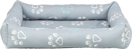 Graues Tierbett mit weißen und hellblauen Pfotenabdrücken auf weicher, gepolsterter Fläche.