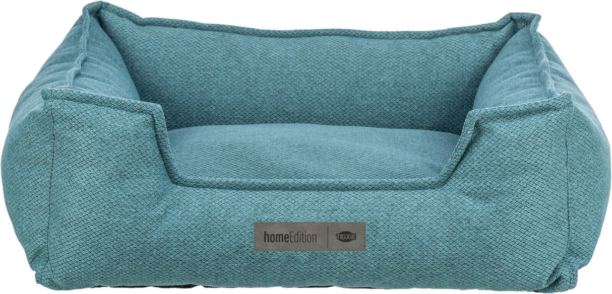 Ein rechteckiges, blaues Tierbett mit erhöhtem Rand, aus texturiertem Stoff, Vorderseite mit „homeEdition“ Label.