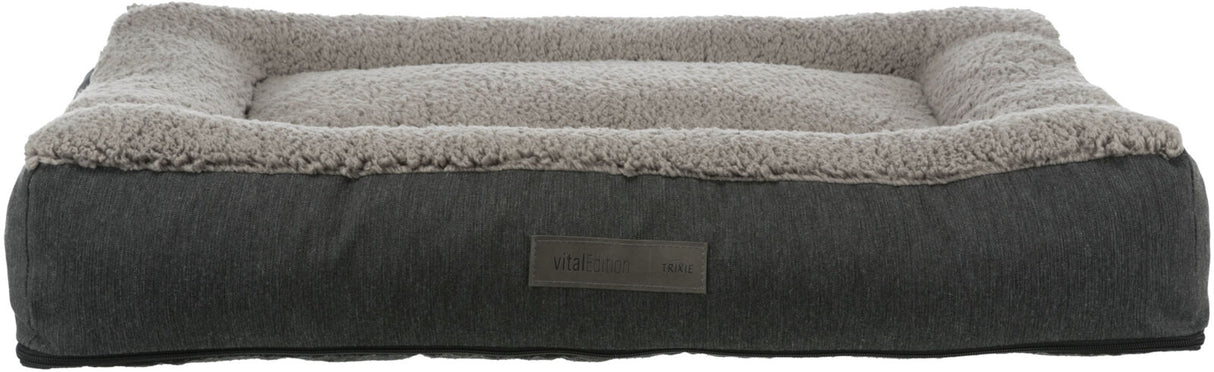 Rechteckiges Hundebett mit grauem Stoffbezug und flauschiger, heller Liegefläche, Label „vital Edition“.
