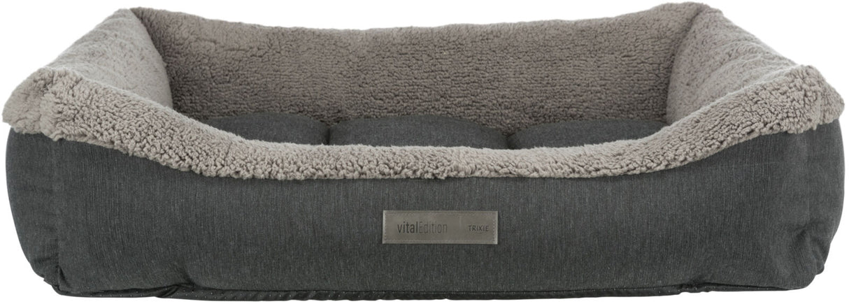 Rechteckiges, graues Haustierbett mit weichem, hellgrauem Rand und einem Textilschild mit Aufschrift "vitalEdition TRIXIE".