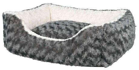 Rechteckiges, grau-weißes Bett mit weichem, fellartigem Bezug und gepolstertem Innenraum.