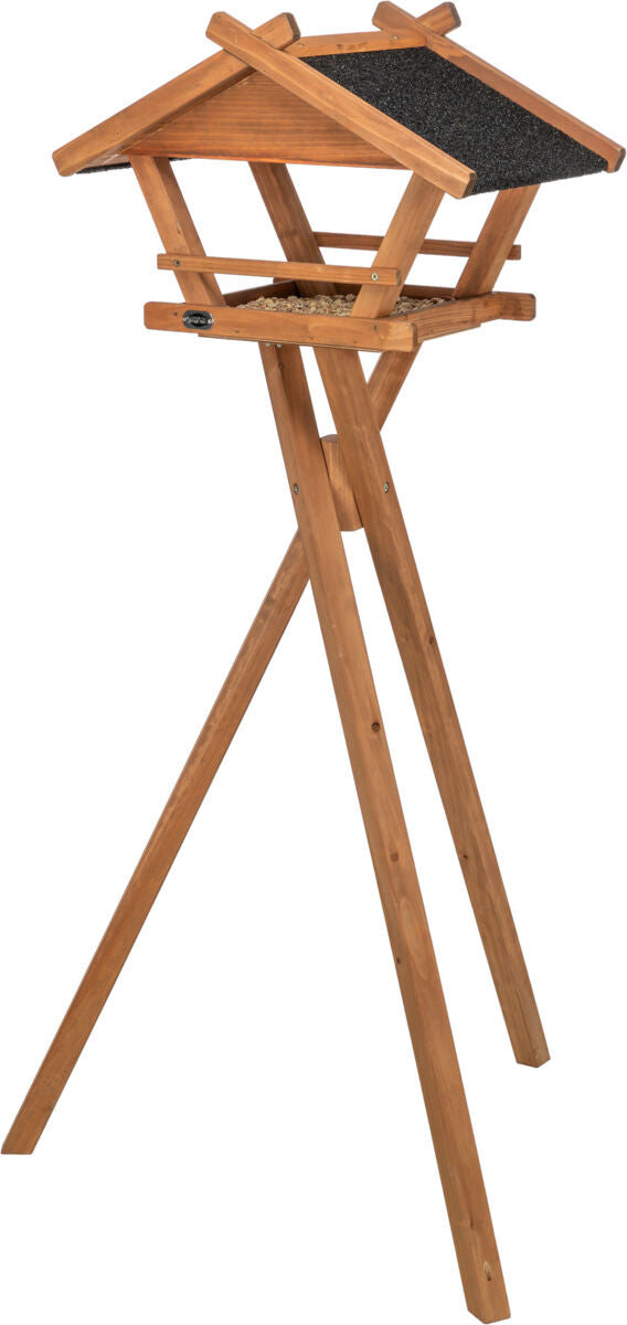 Holz-Vogelhaus auf dreibeinigem Gestell mit schwarzem, schindelartigem Dach und Futter im Inneren.