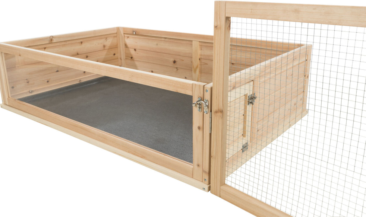 Holzrahmen mit Gitterelementen, als Komponente einer transparenten Gehegeumrandung mit grauem Boden.