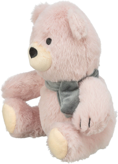 Ein rosa Plüschbär mit schwarzer Nase und Augen trägt einen grauen Schal und sitzt aufrecht.