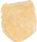 Ein Stück Käse in hellgelblich-beiger Farbe mit ungleichmäßiger, geriffelter Oberfläche.