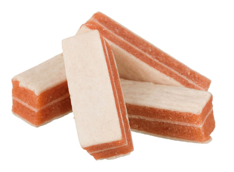 Drei rechteckige, zweifarbige Leckerli mit roten und cremefarbenen Schichten, schräg angeordnet.