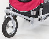 Rotes und schwarzes Fahrradanhänger-Hinterteil mit silbernem Gestell und schwarzem Rad auf weißem Hintergrund.