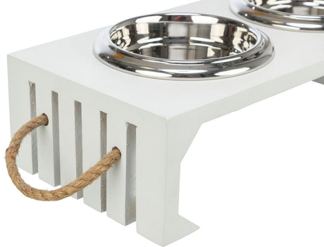 Weiße Futterstation mit zwei runden, silbernen Metallschalen und seitlichem Seilgriff aus Naturfaser.