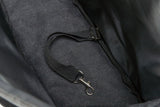 Schwarze Stofftasche mit angenähtem Riemen und silbernem Karabinerhaken im Innenbereich.