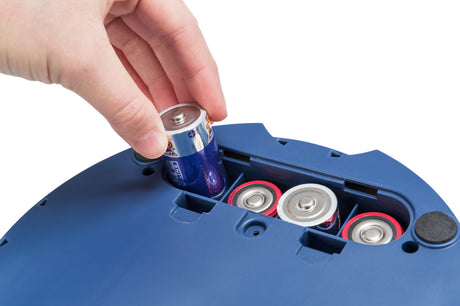 Hand setzt eine große einzelne Batterie in ein blaues Gerät mit weiteren sichtbaren Batterien ein.