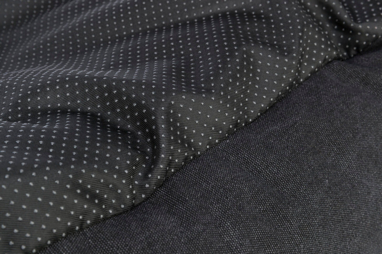 Schwarzer Stoff mit kleinen, weißen Punkten, daneben ein einfarbiger schwarzer, texturierter Bereich.