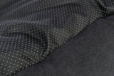 Schwarzer Stoff mit kleinen, weißen Punkten, daneben ein einfarbiger schwarzer, texturierter Bereich.