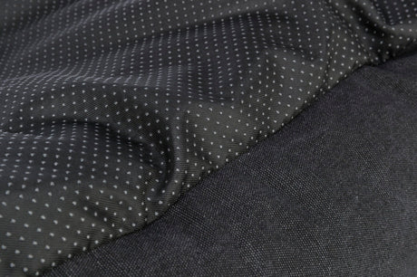 Schwarzer Stoff mit kleinen, weißen Punkten, daneben ein einfarbiger schwarzer, texturierter Bereich.
