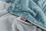 Weiche blaue Plüschdecke mit Pfotenmuster, darunter glatte graue Schicht, Etikett mit Logo "TRIXIE".