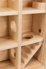 Holzstruktur mit gewinkelten Regalen, runden Öffnungen und einer kleinen Treppe in natürlicher Holzfarbe.