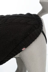 Der graue Hundemantel aus Strick mit Zopfmuster liegt auf einer grauen Figur, ein Trixie-Label ist sichtbar.