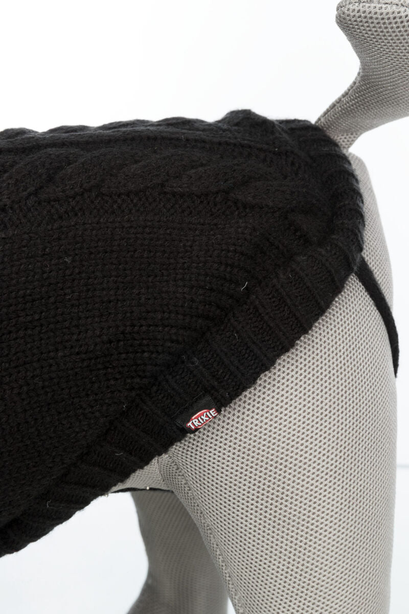 Der graue Hundemantel aus Strick mit Zopfmuster liegt auf einer grauen Figur, ein Trixie-Label ist sichtbar.