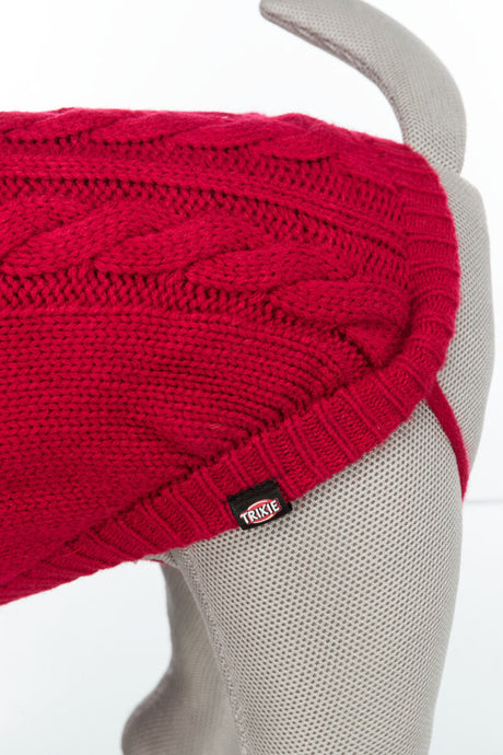 Roter Strickhundepullover mit Zopfmuster auf grauer Hundepuppe, Etikett mit Aufschrift "TRIXIE".